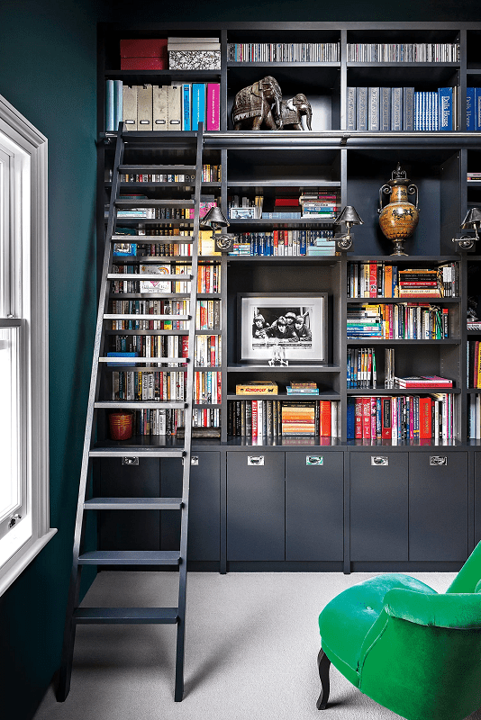 Bold-cozy-modern-reading-nook-with-green-arm-chair-and-floor-to-ceiling-black-built-ins