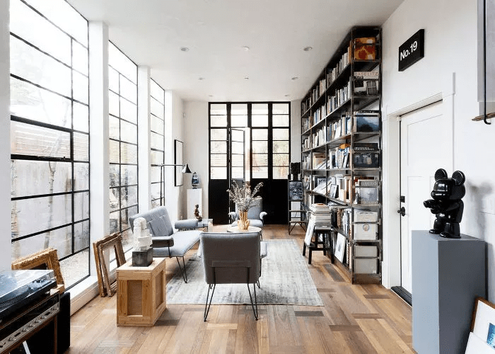 modern-living-room-with-high-bookshelves-and-natural-light